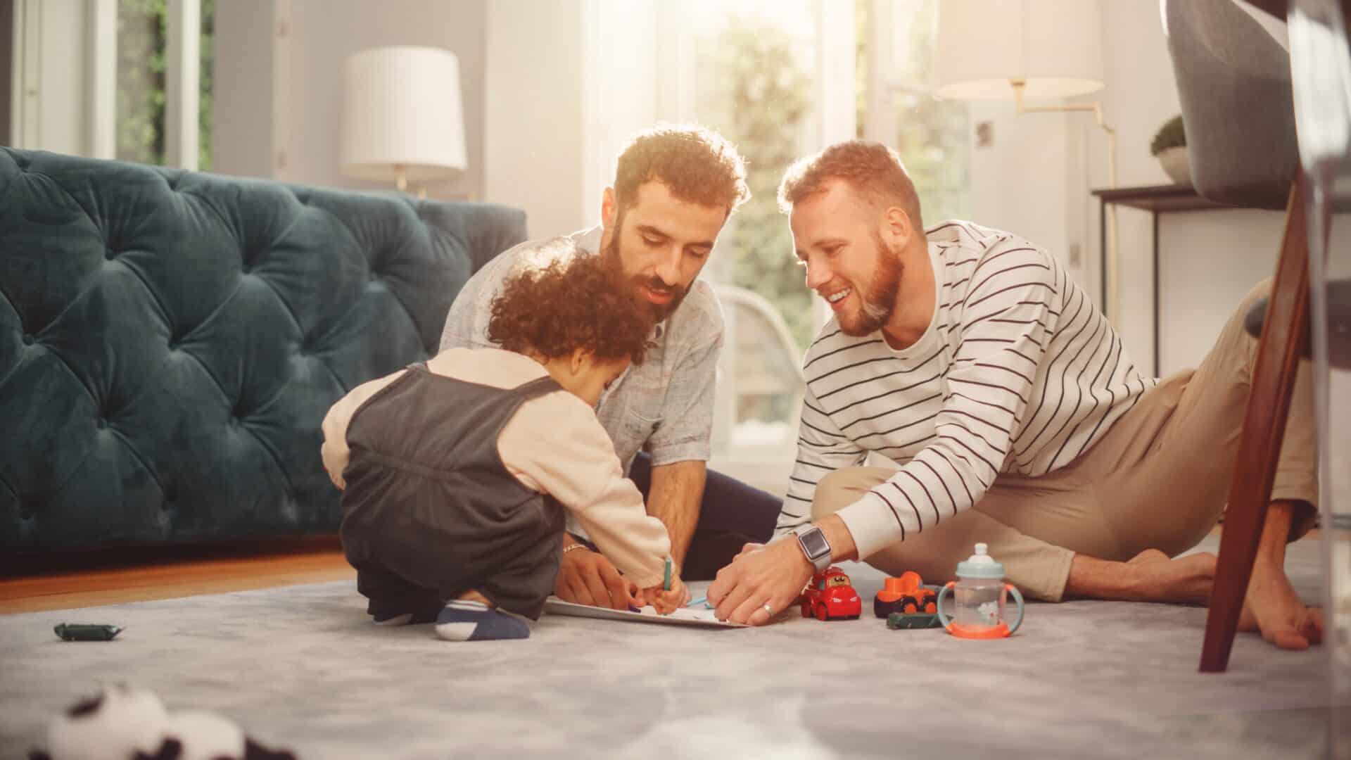 A joyful family scene in a sunlit living room. Two adults and a child sit on the floor, playing with toy cars and coloring, surrounded by a cozy sofa.