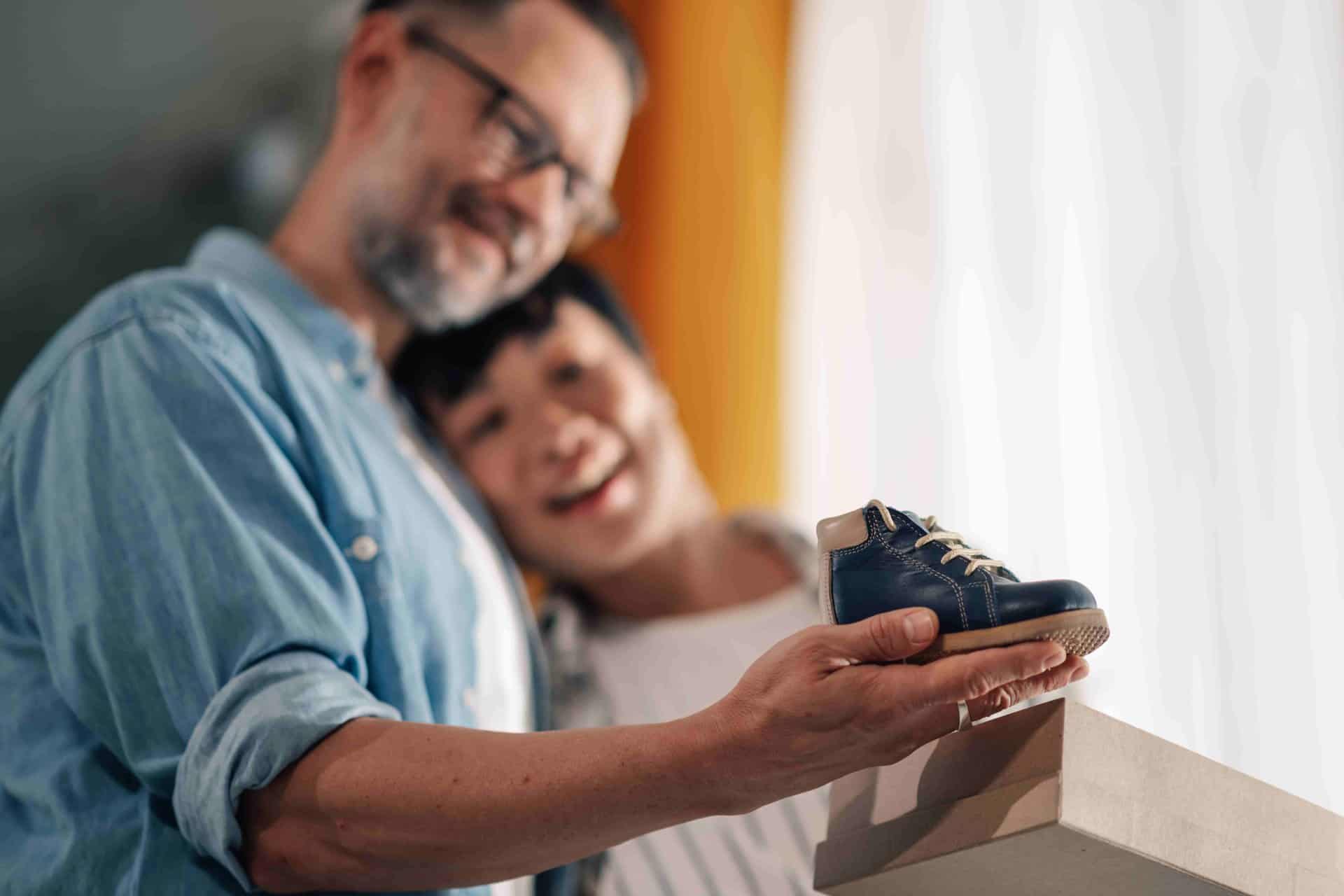 couple holding a baby shoes and thinking about How to Start the Surrogacy Process